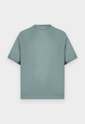 Απλή, σκουρόχρωμη πράσινη κοντομάνικη μπλούζα με στρογγυλή λαιμόκοψη, χαλαρή εφαρμογή, απλωμένη επίπεδη πάνω σε ανοιχτό φόντο.