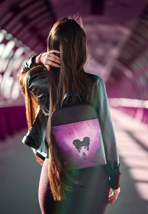 Schwarzer Rucksack aus Kunstleder mit einem lila Motiv, das eine Cartoon-Figur zeigt, verstellbare Riemen und eine glatte Textur.