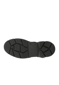 Schwarze Gummi-Sohle mit einem Profil, das geometrische Formen und Rillen für Traktion aufweist. Flaches Design geeignet für verschiedene Geländetypen.