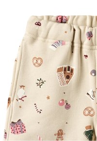 Beige stoff med festlige mønstre av godteri, gaver, julepynt og kringler; har en elastisk midjebånd for komfort.