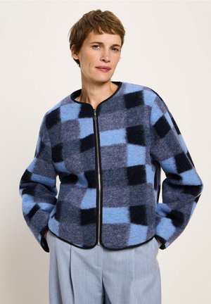 Blue and black checkered wool jacket with a zip front, round neck, and soft texture. Includes black trim along the edges.