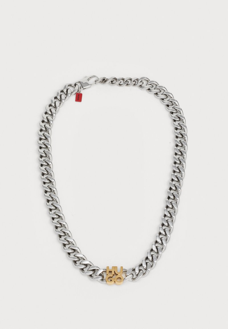 Silberfarbener Metallkettenanhänger mit großen Gliedern, versehen mit einem kleinen goldfarbigen 'Hugo'-Logo-Akzent und einem Verschluss mit einem roten Etikett.