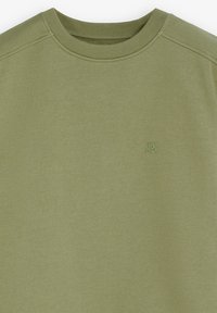 Sudadera verde oliva con cuello redondo, de material de algodón, puños acanalados y un pequeño logo bordado en el pecho. Tejido suave y texturizado.