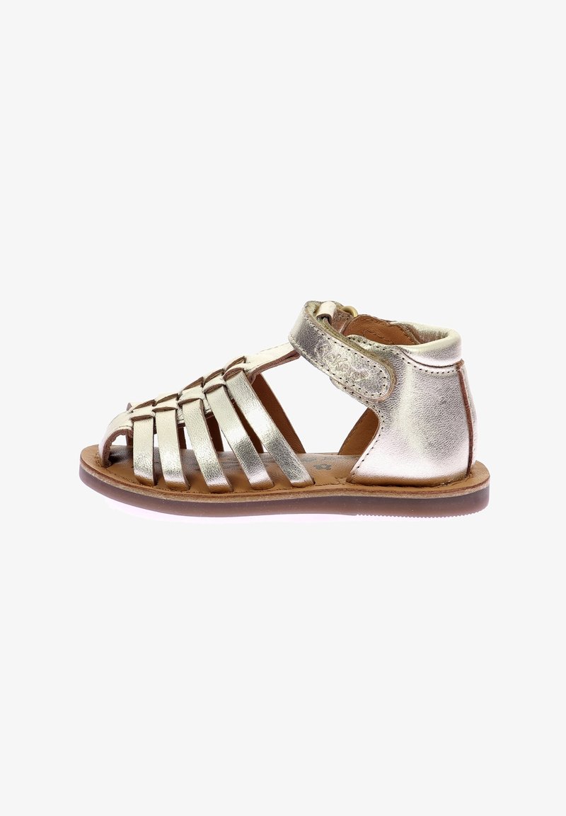 Sandale en cuir à bout ouvert pour enfant avec des brides métalliques et un soutien de la cheville, attachée par une fermeture velcro latérale, vue de côté sur fond blanc.