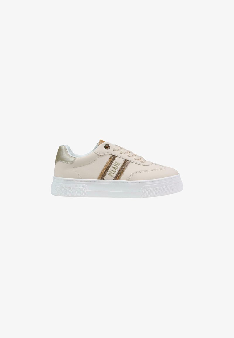 Zapatilla beige de corte bajo con suela blanca, franjas laterales beige y doradas, cordones y detalle metálico dorado en el talón.