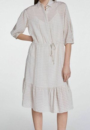 Robe beige clair avec un motif checkered texturé, fermeture à boutons, manches courtes, taille froncée et ourlet à volants en étages.