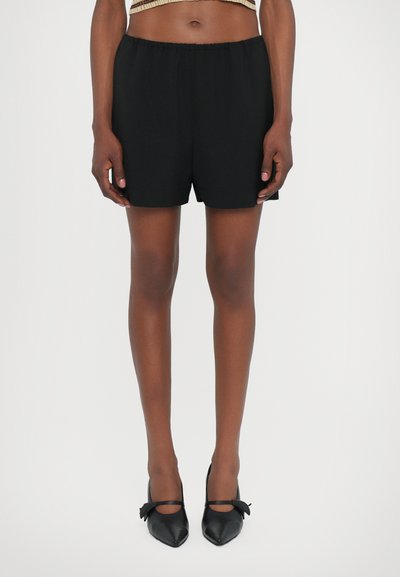 Sorte shorts lavet af glat stof, med en elastisk talje, afslappet pasform og sideskår for nem bevægelse.