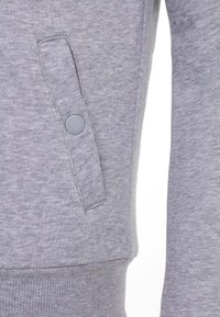 Grijze sweatshirt met een zijklepzak met knoopsluiting, ribgebreide manchetten en een zachte, geprofileerde stof.