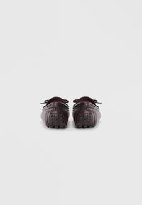Zapatos de cuero marrón con una suela de goma texturada, forma redonda, detalles de cordones y costuras en contraste; diseñados para un uso casual.