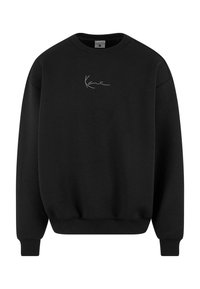 Must mustavärk, mis on valmistatud pehmest kangast, ümmarguse kaelusega ja pikkade varrukatega. Esipanelil on lihtne ja diskreetne tikandlogoga.