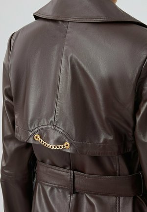 Bruine leren trenchcoat met een grote kraag, een ceintuur in de taille en een gouden kettingaccent op de rugzijde. Soepele textuur, aangepast pasvorm.