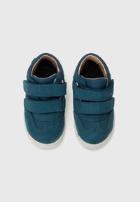 Blaue Lederschuhe mit zwei Klettverschlussriemen, abgerundeter Spitze und kontrastierender weißer Gummisohle, die auf dem Oberteil gestickte Akzente aufweist.