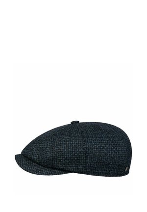 Dark blue and black tweed flat cap with button on top and small metal emblem on the side, shown in profile on white background.