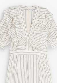Tutina bianca con righe nere verticali, caratterizzata da dettagli a ruffles lungo le maniche e il collo. Presenta un profondo scollo a V e una vita strutturata.