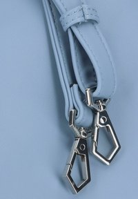 Borsa a mano in pelle sintetica azzurro chiaro con accessori in argento, caratterizzata da due cerniere distinte e una superficie liscia e texture.
