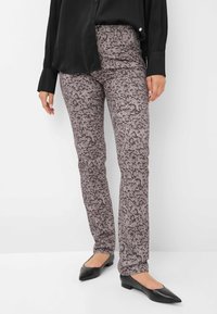 Luipaardprint broek in grijstinten, met een slim fit, een mid-rise taille en een zachte stoftextuur. Gecombineerd met een zwarte blouse en puntige flats.