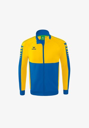 Gelbe und blaue Trainingsjacke mit Reißverschluss, hohem Kragen, vertikalen Seitenstreifen und Logo auf der Brust und den Ärmeln. Weicher Stoff.