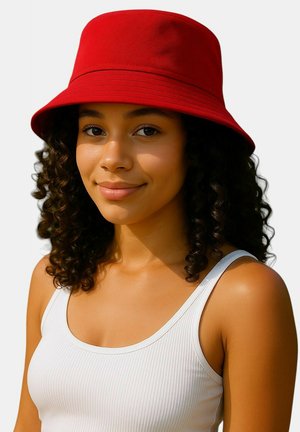 Rode katoenen bucket hat met een brede rand en textuurstof, gedragen door een persoon met krullend haar, gecombineerd met een witte tanktop.