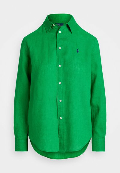 Cămașă lungă cu mâneci din in verde, cu guler ascuțit, placket cu nasturi și un mic logo brodat pe piept. Textură netedă, margine curbată.
