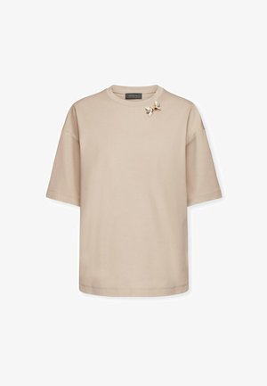 Beige T-shirt met korte mouwen van zachte stof, met een bloemenbroche accent op de linkerschouder en een ronde halslijn.