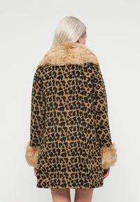 Plašč z leopardjim vzorcem in umetnim krznenim ovratnikom in manšetami. Zasnovan v sproščenem kroju, s toplimi odtenki rjave in črne barve za teksturiran videz.