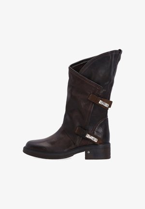 Brązowe skórzane kozaki za kolano z założonym czubkiem, dekoracyjnymi paskami i metalowymi akcentami. Mają masywny obcas i fakturowane wykończenie.