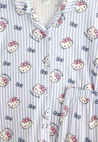 Hello Kitty pyjama-setti, joka sisältää sinivalkoraidallista kuosia, vaaleanpunaisia nastoja ja sarjakuvahahmojen kuvastoja. Setti on valmistettu pehmeästä kankaasta, jossa on nappidetailia.