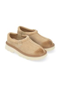 Lichtbruine suède instappers met een ronde neus, elastische zijpanelen en een chunky witte rubberen zool. Contraststiksels accentueren het ontwerp.