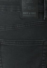 Blugi din denim negri cu un finisaj texturat, având o cusătură vizibilă la buzunarul din spate și o etichetă din piele cu marca "ONLY & SONS."