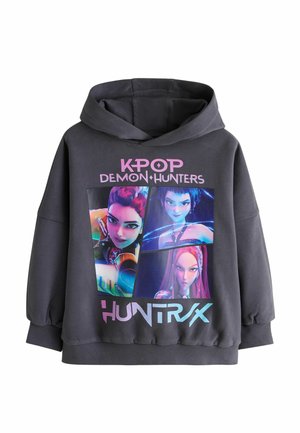 Black hoodie with colorful animated K-pop Demon Hunters characters and pink and blue text "K-POP DEMON HUNTERS HUNTRAX" on the front.