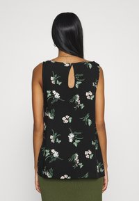 Black floral tank top featuring small pink flowers and green butterflies, with a keyhole detail at the back and a loose fit.