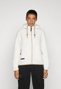 Witte fleecejack met een textuurdesign, capuchon en beige accenten. Voorzien van voorzakken en een ritssluiting met trekstangen.