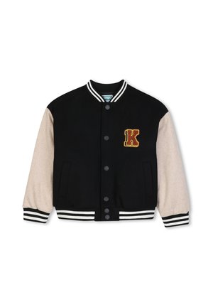 Veste varsity noire avec manches beiges, poignets et col rayés, boutons-pression, et un écusson jaune et rouge en forme de lettre K sur la poitrine.