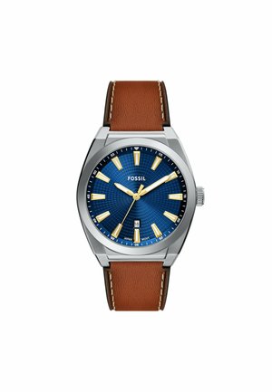 Montre pour homme Fossil avec un boîtier en acier inoxydable, un cadran texturé bleu, des index en or et un bracelet en cuir marron avec des coutures blanches.