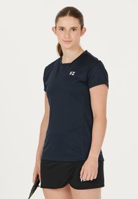 Marineblå sports T-shirt med korte ærmer og rund halsudskæring, med et hvidt "FZ" logo, parret med en sort skort.