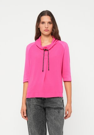 Roze pullovertop met een kraag en een verstelbare trekkoord. Heeft driekwartmouwen en een relaxte pasvorm, gemaakt van zachte stof.