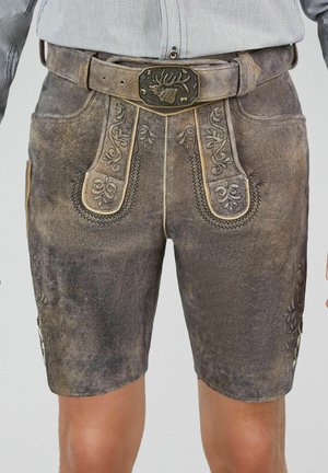 Shorts traditionnels en cuir marron usé avec des motifs floraux brodés et une ceinture ornée d'une boucle en forme de tête de cerf.