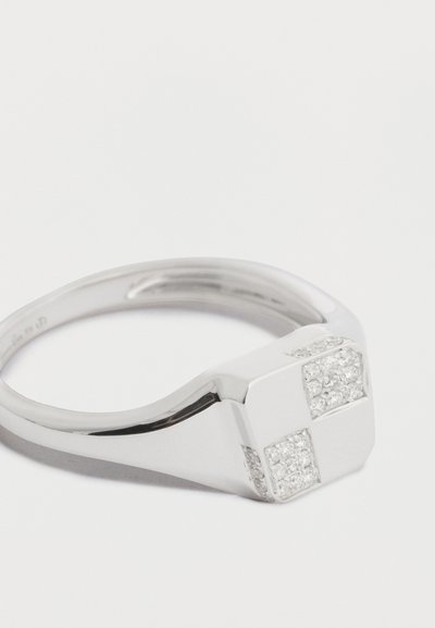 Stříbrný prsten s lesklým povrchem, zdobený geometrickými akcenty a čtvercovým motivem se zasazenými malými průhlednými kameny.