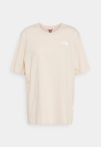 T-shirt in cotone beige con vestibilità rilassata, scollatura rotonda e maniche corte. Presenta un piccolo logo bianco sull'area sinistra del petto.