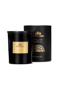 Barattolo di candela nera con etichetta dorata, che presenta "Royal Oudh & Patchouli". Accompagnato da un tubo di imballaggio nero con un motivo decorativo.