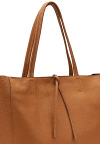 Borsa a tote in pelle marrone con una finitura martellata, dotata di due lunghe tracolle e una chiusura a cordoncino, linee pulite e design minimalista.
