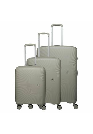 Drie beige harde koffers met telescopische handvatten en vier zwenkwielen, gerangschikt van klein naar groot.