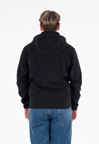 Giacca nera con cappuccio dalla trama liscia, caratterizzata da un design semplice e cappuccio regolabile, abbinata a pantaloni di jeans blu.