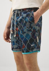 Shorts de bain en bleu, noir et rouge avec un motif mosaïque, dotés d'une ceinture élastique, de poches latérales et d'une étiquette logo sur l'ourlet.