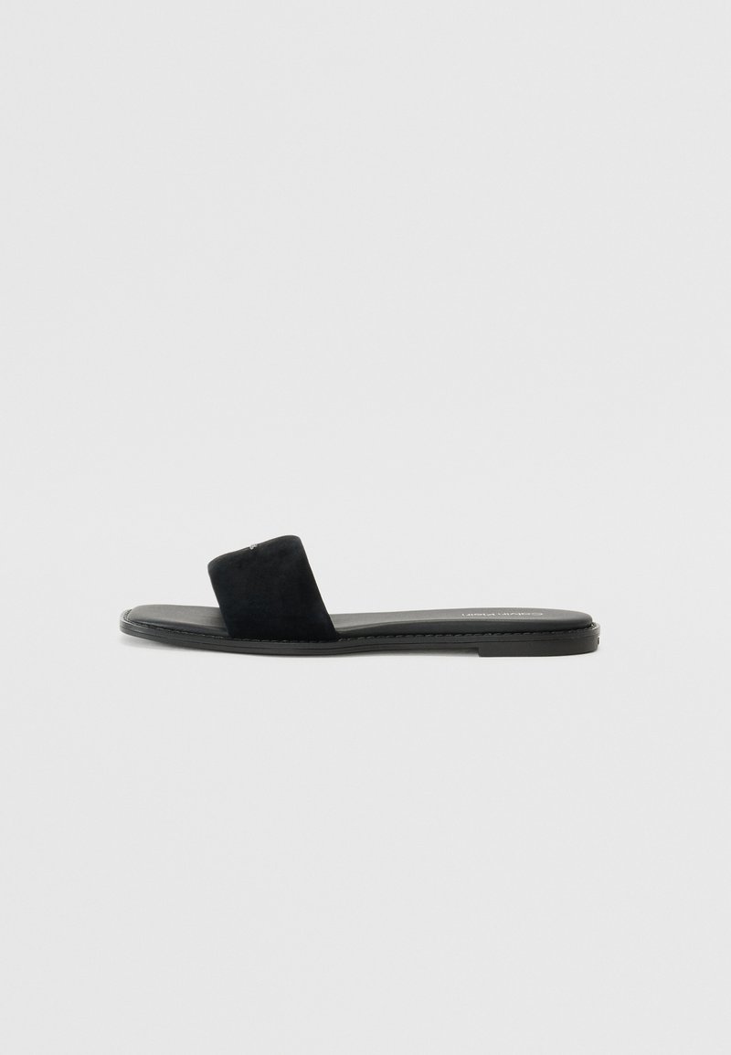 Sorte flate sandaler med bred rem, sueded tekstur, minimalistisk design og glatt såle. Lettvekts og passende for uformell bruk.