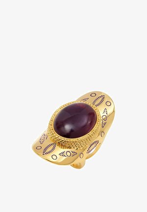 Bague en ton doré ornée d'une pierre ovale rouge foncé, avec des détails texturés et des accents gravés dans un motif répétitif le long de l'anneau.