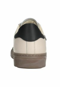 Baskets en cuir crème avec un empiècement de talon noir et une semelle en caoutchouc brun texturé. Présente des détails cousus le long de l'arrière.