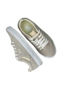 Grijze Vans sneakers gemaakt van een mix van suede en canvas, met witte veters en een witte rubberen zool. Logo zichtbaar op de zijkant.