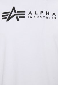 Hvid bomulds t-shirt med et sort trykt logo, der kombinerer stiliserede bogstaver "A" og "L" med vandrette striber, placeret på brystområdet.