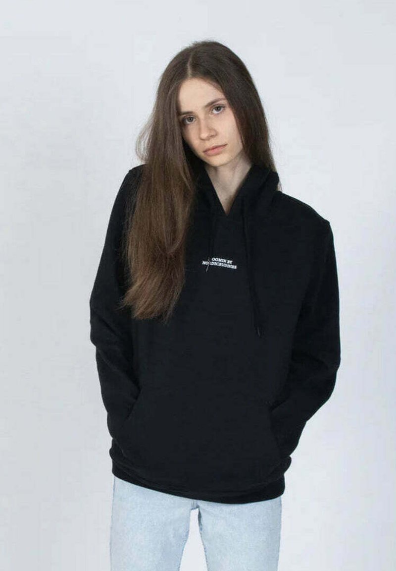 Musta huppari, jossa on naru. Vaatteessa on pieni valkoinen logo rinnassa. Yhdistetty vaaleansinisiin farkkuihin. Yksinkertainen muotoilu.